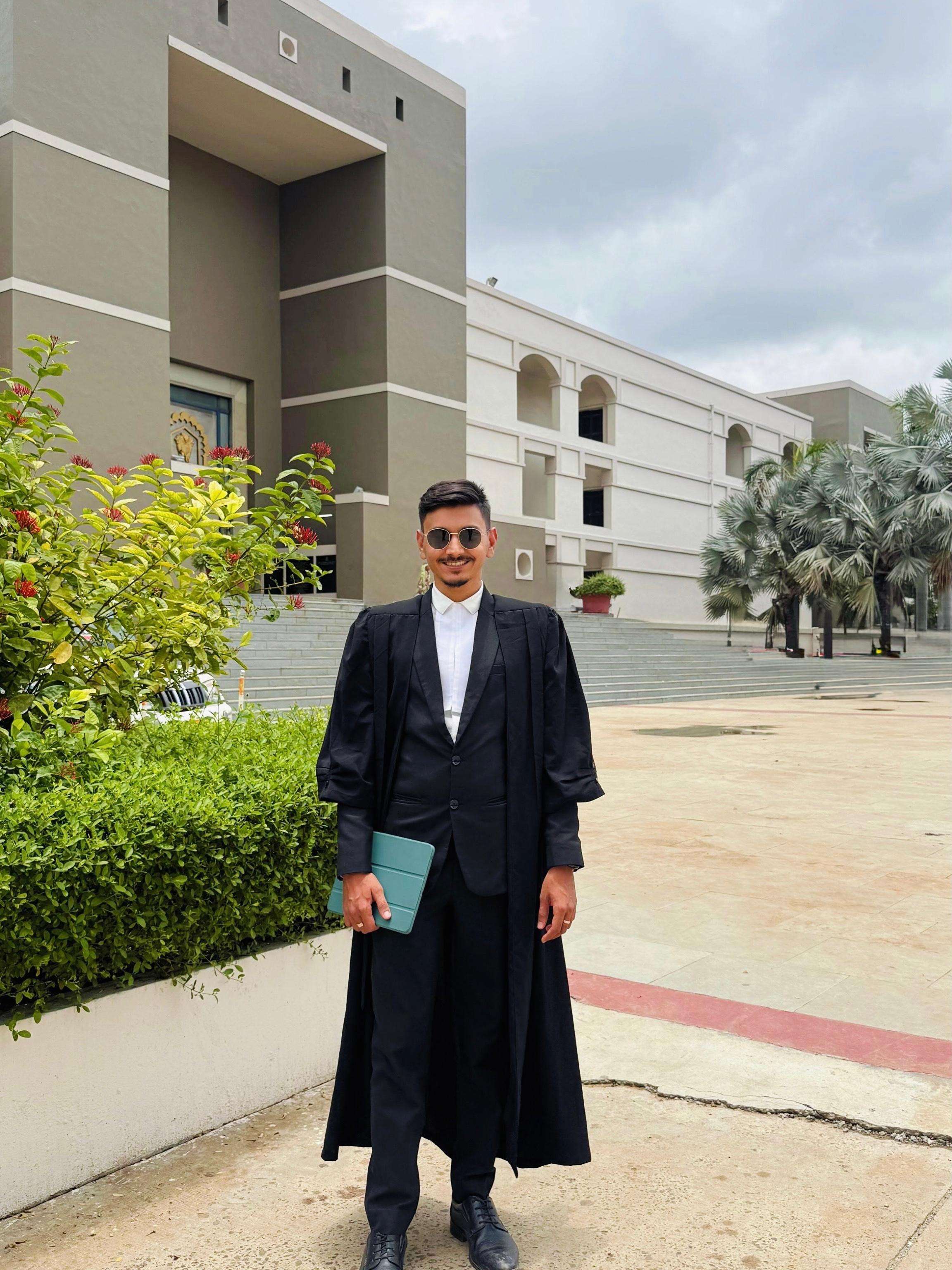 Adv. Prem Shah seated at a desk in a dark suit